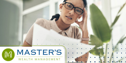 Woman with her hand on her head looking at papers, wondering if it's time to consider a wealth advisor.