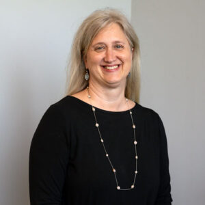 Krista Myer in a black shirt, smiling.