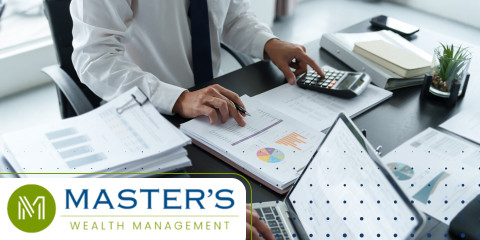 Man in a suit reviews his tax documents with a calculator while determining if tax-loss harvesting is right for him.