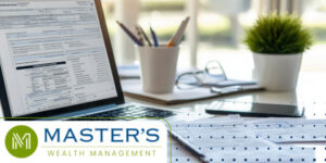 Desk with 2026 tax forms on a laptop and paper copies strewn across the surface.